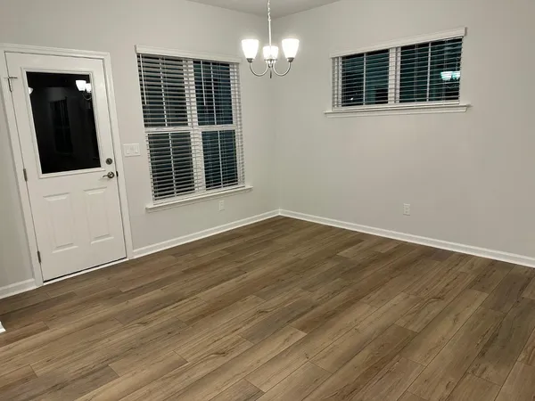 a view of a livingroom with wooden floor and windows