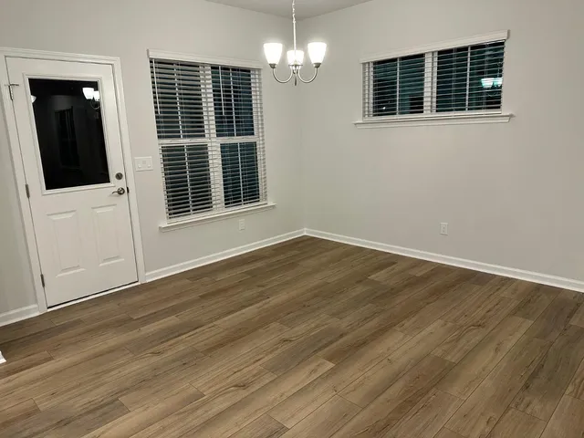 a view of a livingroom with wooden floor and windows