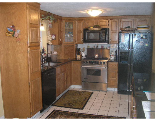 7 Argonne Road Billerica, MA 01821 - Photo 8 of 16 a kitchen with granite countertop a refrigerator and a stove