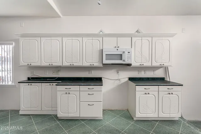 a kitchen with granite countertop white cabinets and sink