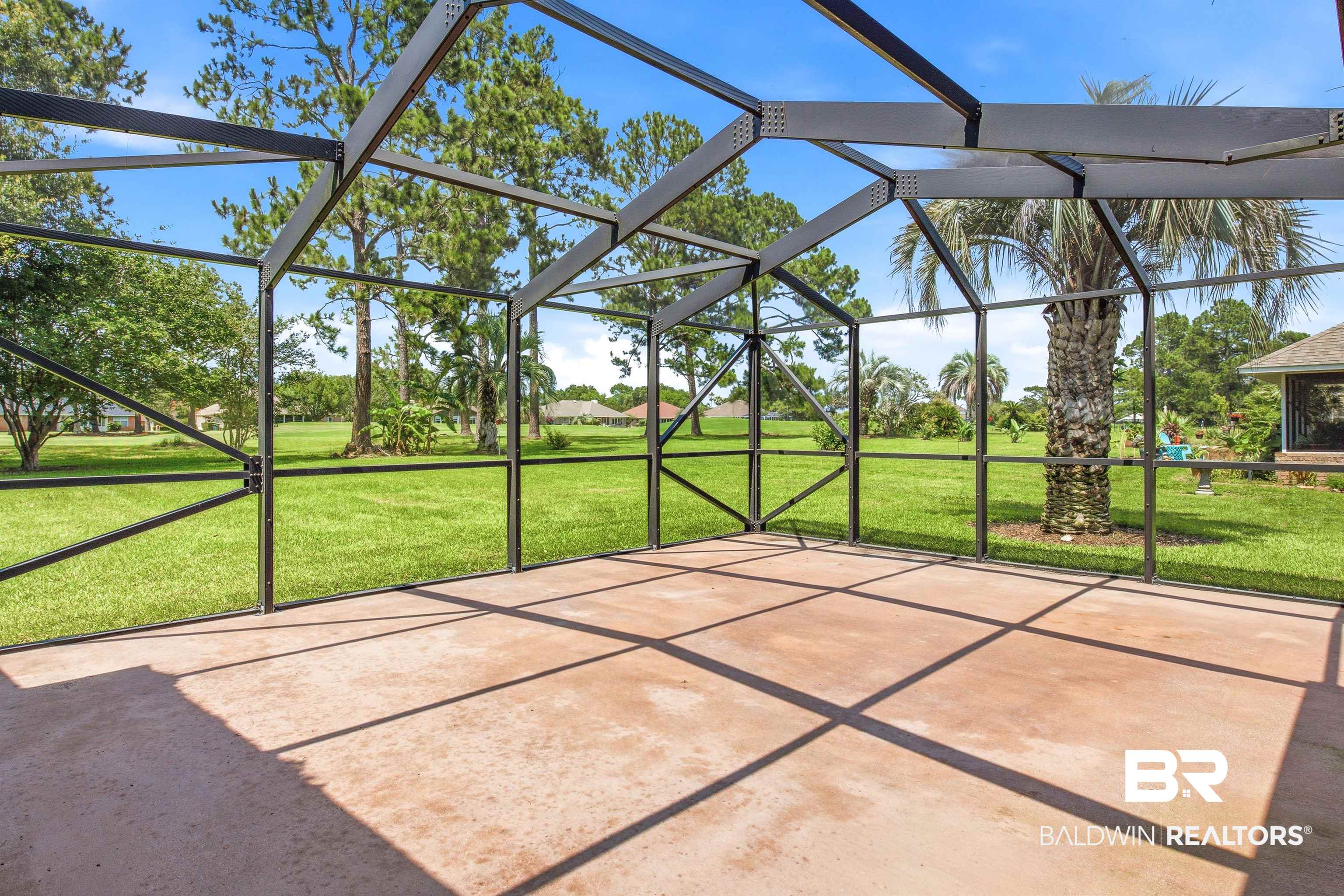 22685 County Road 12 Foley, AL 36535 - Photo 17 of 89 Expansive screened enclosure featuring a concrete patio, a structured metal frame, and a wide-open lawn beyond