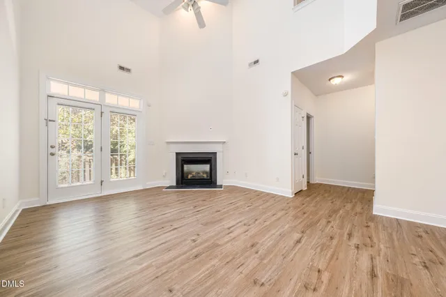 an empty room with wooden floor and fireplace