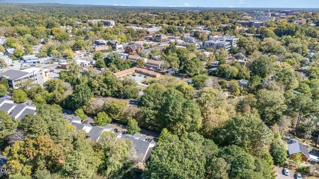 an aerial view of residential house with outdoor space and trees all around