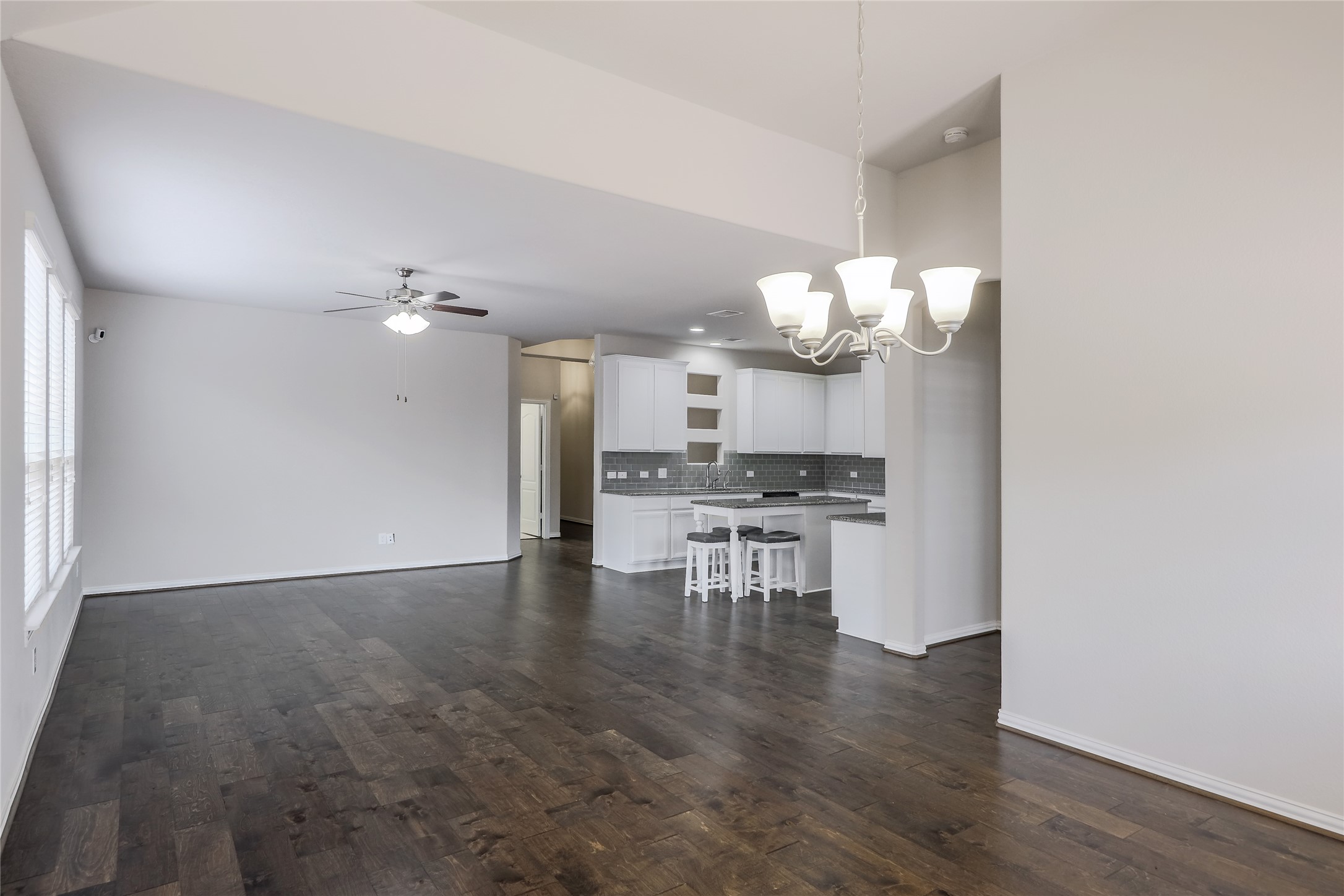 205 Penna Lane Georgetown, TX 78628 - Photo 7 of 32 Rich hardwood floors unite an open-concept living space with a pristine, modern kitchen.