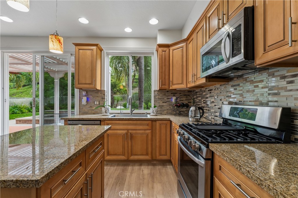 26023 Salinger Lane Stevenson Ranch, CA 91381 - Photo 5 of 35 Beautiful gourmet kitchen featuring high-end stainless steel appliances, custom cabinetry, quartz countertops, and a spacious center island perfect for entertaining.