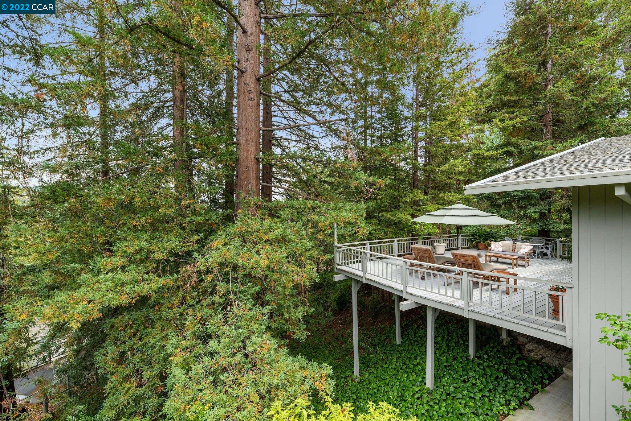 a backyard of a house with table and chairs under an umbrella