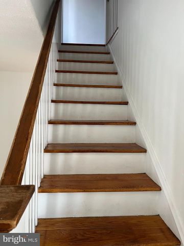 an empty room with wooden floor cabinet and windows