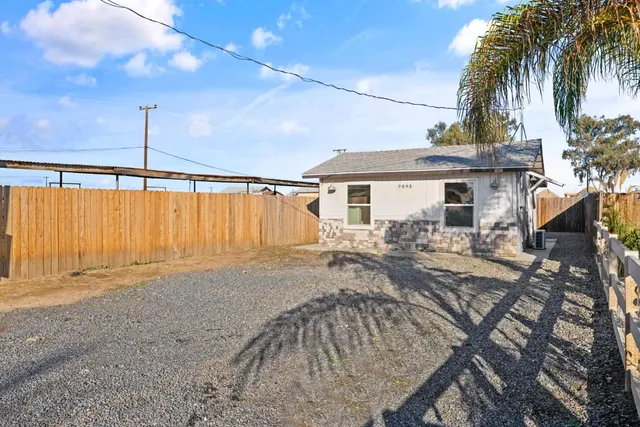 a view of a house with backyard and sitting area