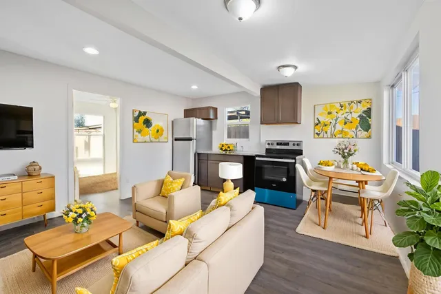 a living room with furniture kitchen view and a window