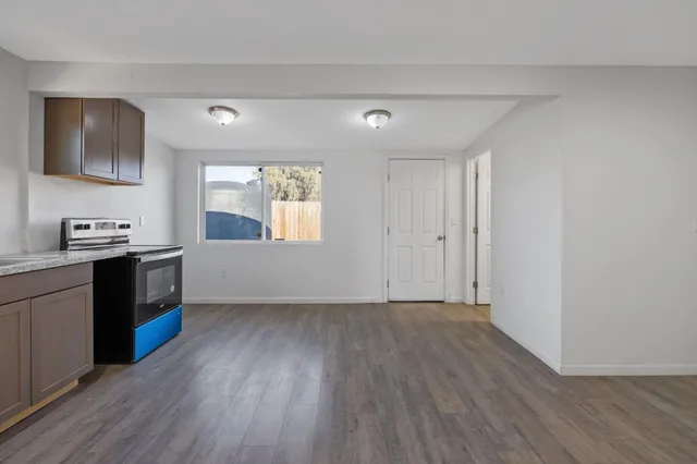 a view of a kitchen with wooden floor and electronic appliances