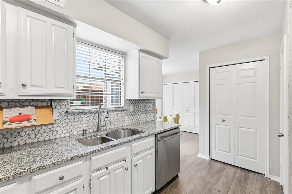 4020 Windhaven Lane Dallas, TX 75287 - Photo 11 of 32 a kitchen with stainless steel appliances granite countertop white cabinets sink and window