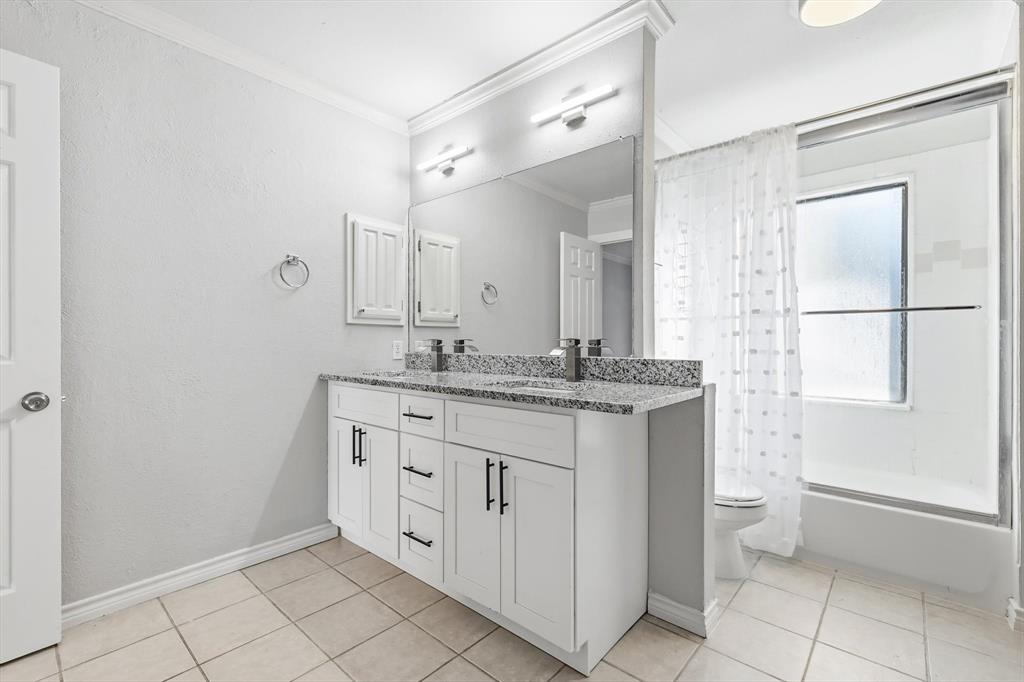 4020 Windhaven Lane Dallas, TX 75287 - Photo 16 of 32 a bathroom with a granite countertop sink a toilet a mirror and shower