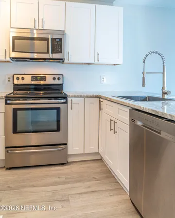 a kitchen with stainless steel appliances a stove microwave and sink