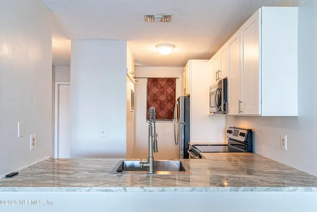 a view of a kitchen with kitchen island a sink and wooden floor