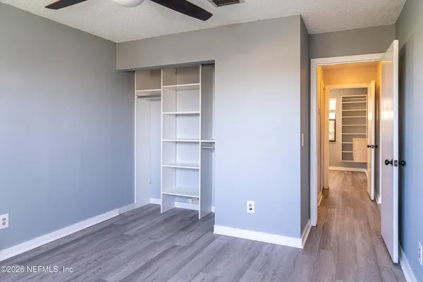 a view of empty room with wooden floor