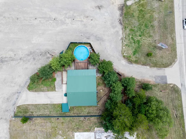 a kitchen with stainless steel appliances granite countertop a refrigerator a sink dishwasher a stove and white countertops with wooden floor