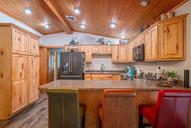 a kitchen with sink refrigerator dining table and chairs
