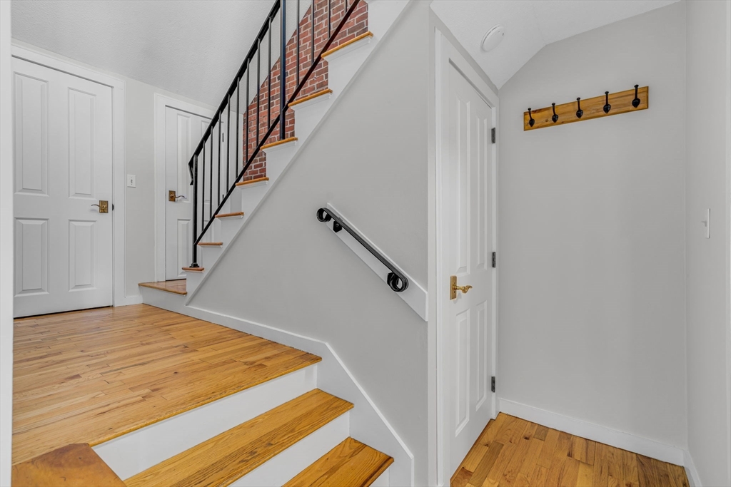 403 Great Road, Unit 5 Acton, MA 01720 - Photo 15 of 25 a view of a hallway with wooden floor and staircase