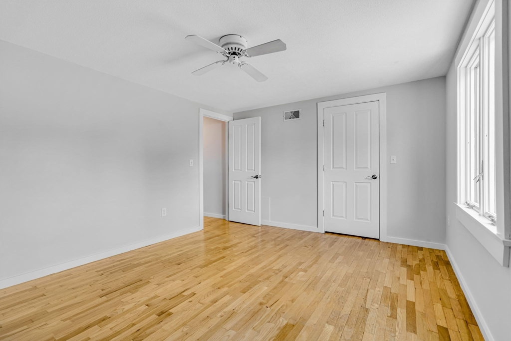 403 Great Road, Unit 5 Acton, MA 01720 - Photo 20 of 25 a view of empty room with wooden floor and fan
