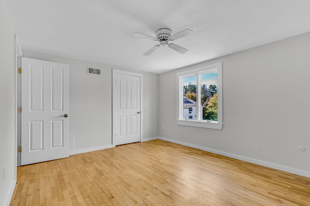 403 Great Road, Unit 5 Acton, MA 01720 - Photo 21 of 25 a view of an empty room with wooden floor and a window
