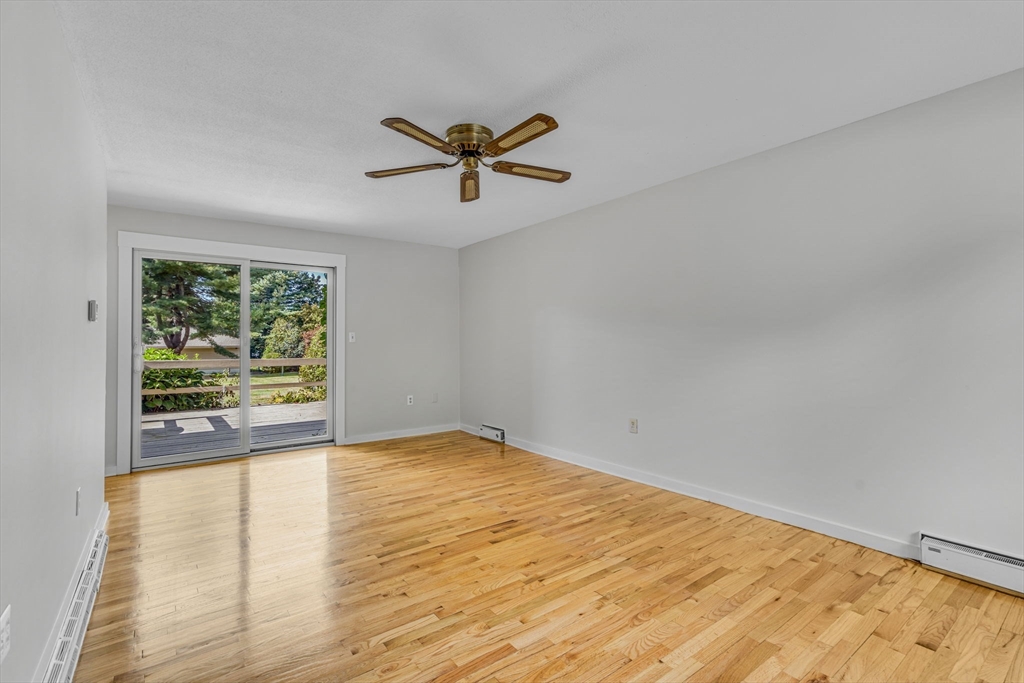 403 Great Road, Unit 5 Acton, MA 01720 - Photo 6 of 25 a view of empty room with wooden floor and fan