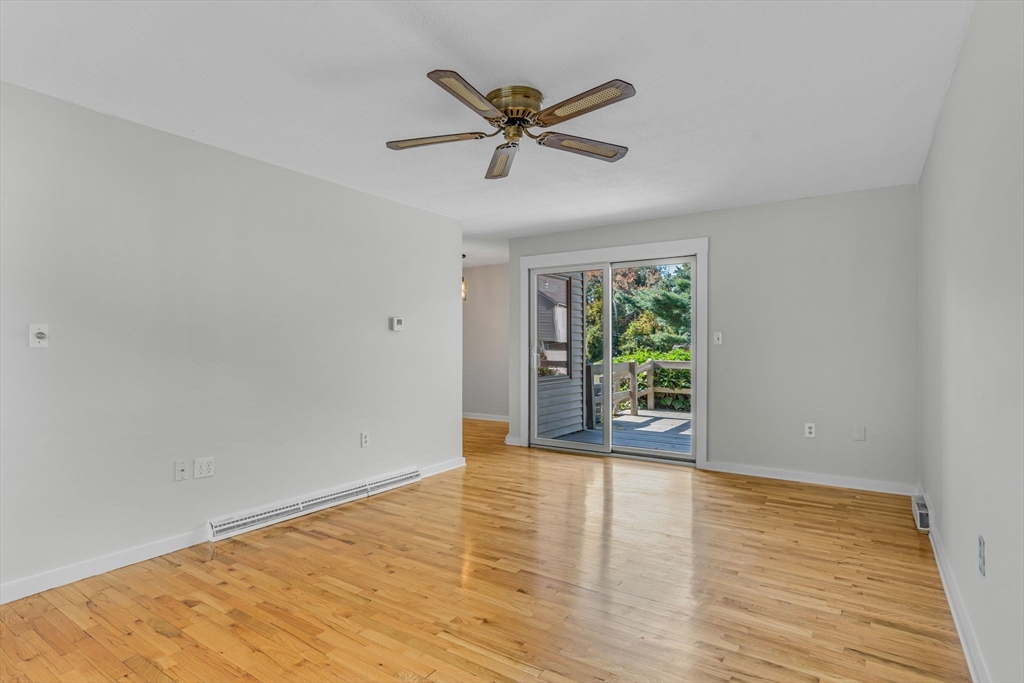 403 Great Road, Unit 5 Acton, MA 01720 - Photo 7 of 25 a view of an empty room with wooden floor and a window