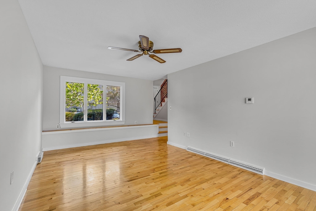 403 Great Road, Unit 5 Acton, MA 01720 - Photo 8 of 25 a view of empty room with wooden floor and fan
