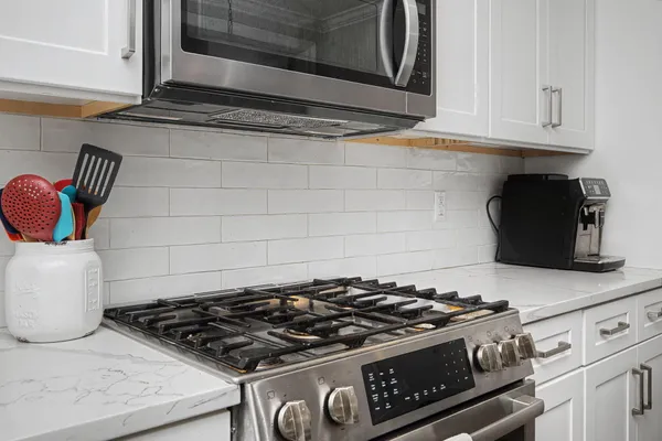 a stove top oven sitting inside of a kitchen