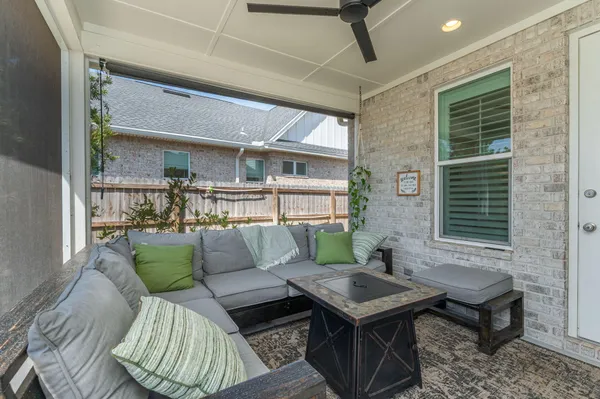 a view of a patio with table and chairs potted plants with floor to ceiling window and potted plants
