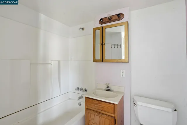 a bathroom with a toilet a sink a bath tub and mirror