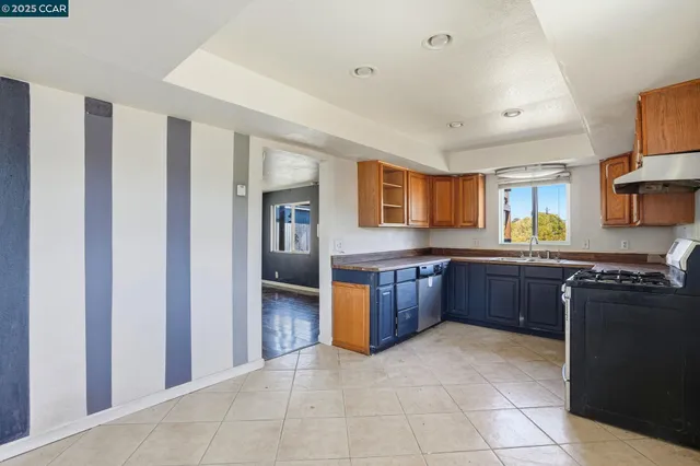 a kitchen with stainless steel appliances granite countertop a refrigerator and a stove top oven
