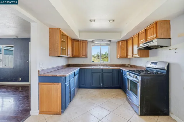 a kitchen with stainless steel appliances granite countertop a stove a sink dishwasher and a refrigerator