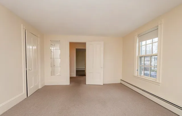 an empty room with windows and closet