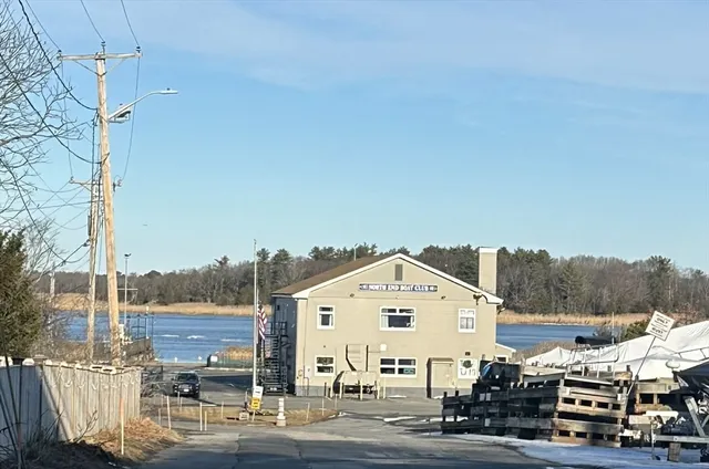 a front view of a building with streets and trees