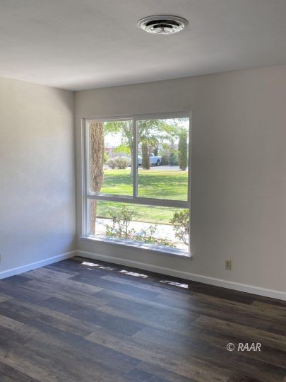 1010 Peg Street Ridgecrest, CA 93555 - Photo 4 of 17 a view of an empty room with wooden floor and a window