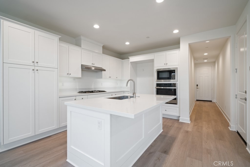 1211 Providence Loop Placentia, CA 92870 - Photo 6 of 20 a large kitchen with stainless steel appliances a stove a sink dishwasher and a refrigerator with wooden floor