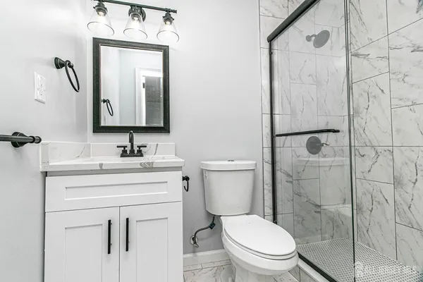 a bathroom with a toilet sink vanity and mirror