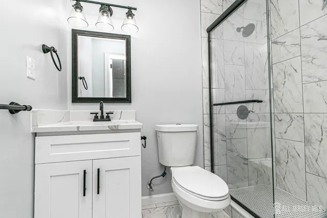 a bathroom with a toilet sink vanity and mirror