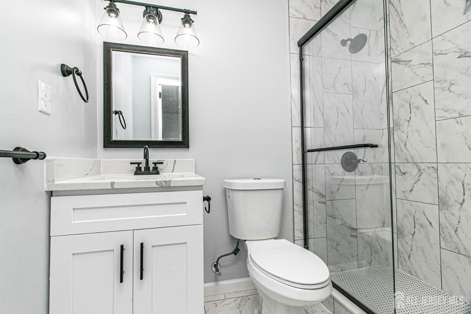 10 Codington Place, Unit 2 Somerville, NJ 08876 - Photo 14 of 14 a bathroom with a toilet sink vanity and mirror