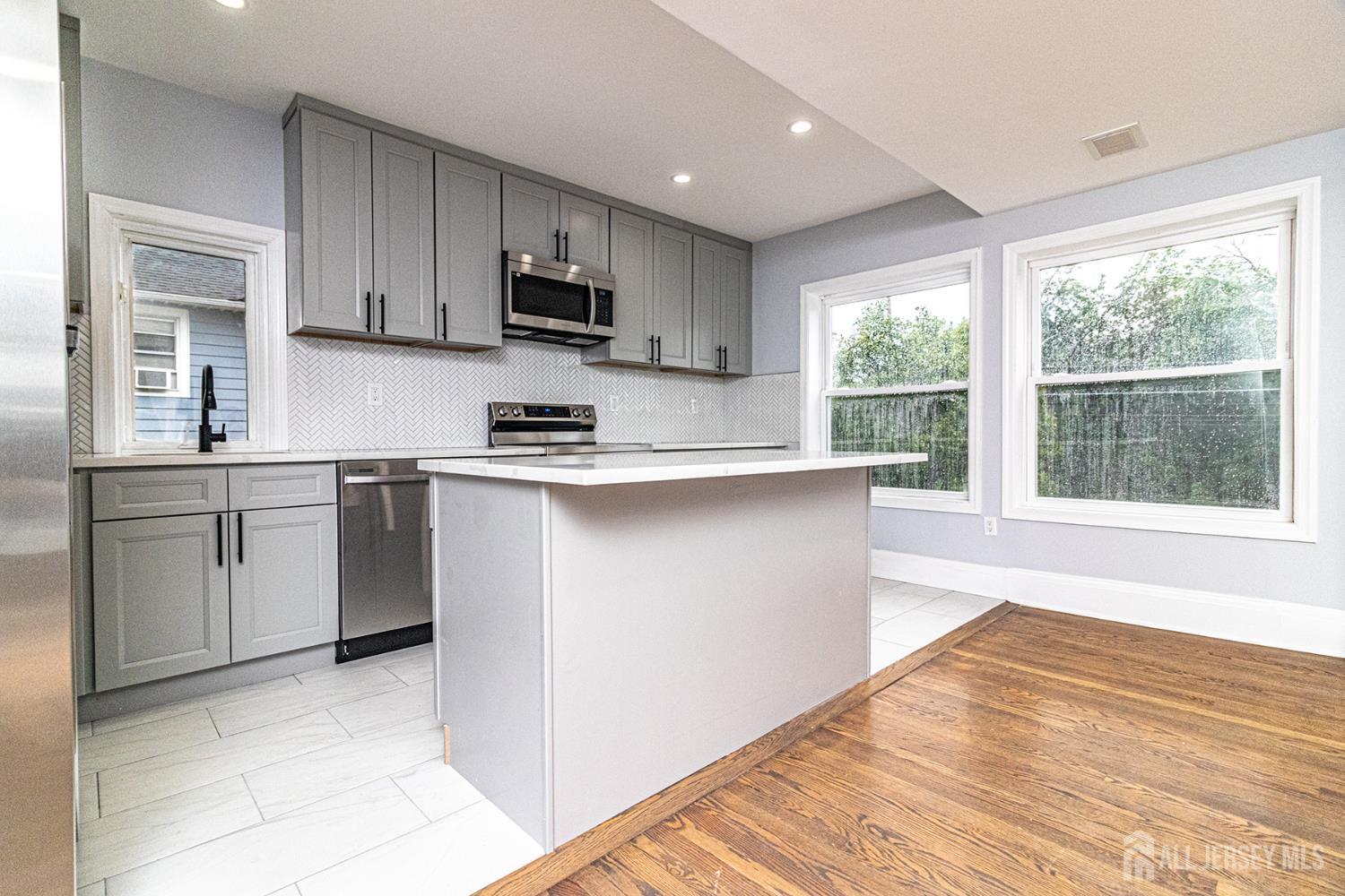 10 Codington Place, Unit 2 Somerville, NJ 08876 - Photo 3 of 14 a kitchen with stainless steel appliances granite countertop a stove a sink and white cabinets