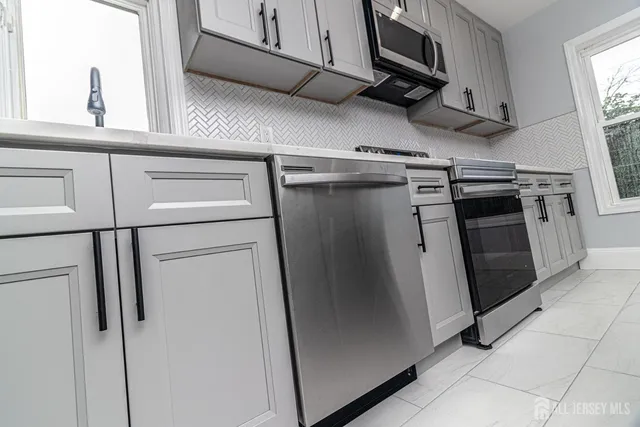 a view of a kitchen with stainless steel appliances and a window