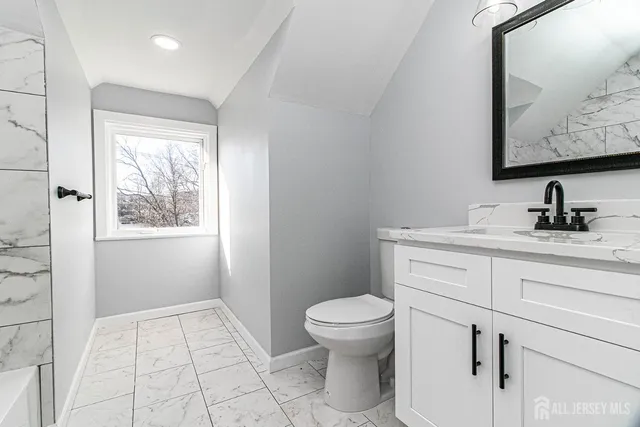 a bathroom with a toilet sink and mirror