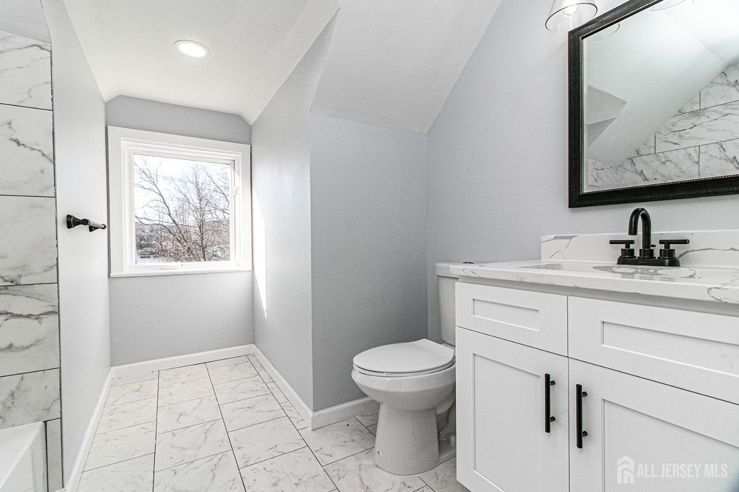 10 Codington Place, Unit 2 Somerville, NJ 08876 - Photo 9 of 14 a bathroom with a toilet sink and mirror