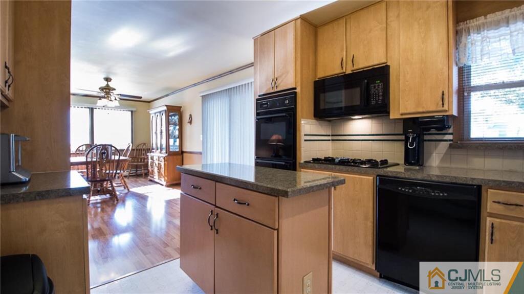 15 Eastlick Road Edison, NJ 08817 - Photo 7 of 23 a kitchen with stainless steel appliances a stove a sink dishwasher a microwave oven with cabinets and wooden floor
