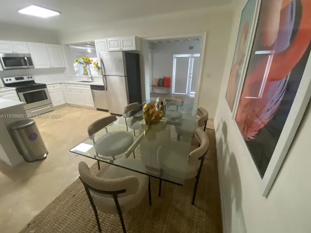 a kitchen with stainless steel appliances kitchen island granite countertop sink refrigerator and microwave