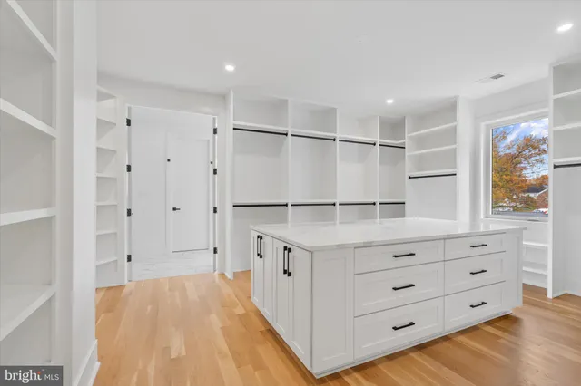 a kitchen with white cabinets and window