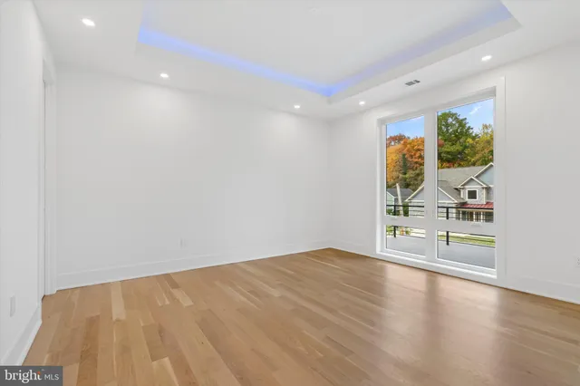 a view of empty room with wooden floor and fireplace