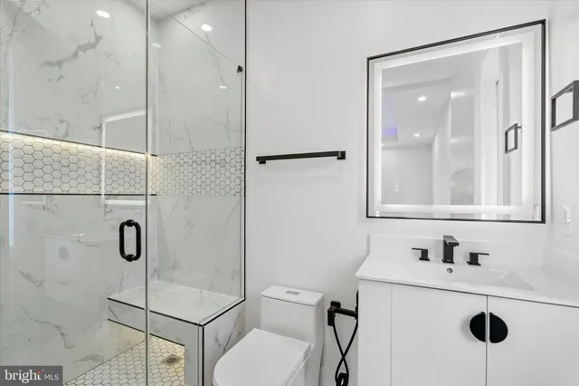 a bathroom with a sink mirror vanity and toilet