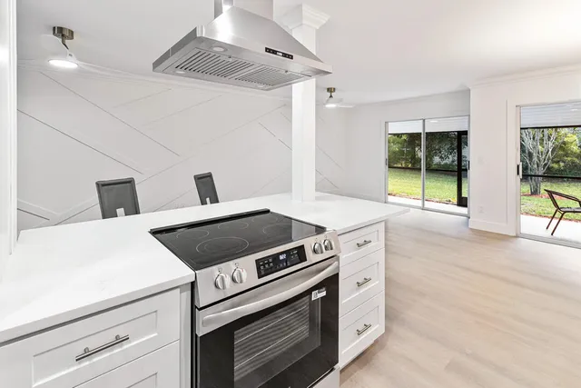 a living room with stainless steel appliances kitchen island furniture and a kitchen view
