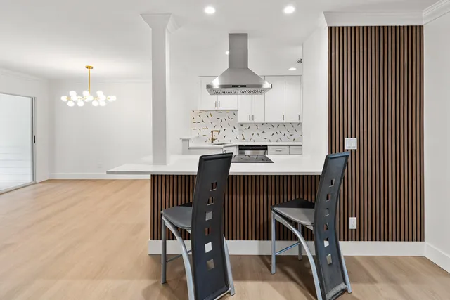 a utility room with stainless steel appliances white cabinets and a sink